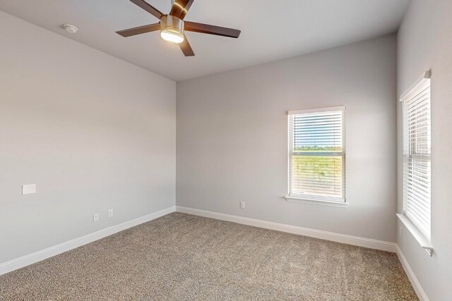 carpeted spare room featuring ceiling fan