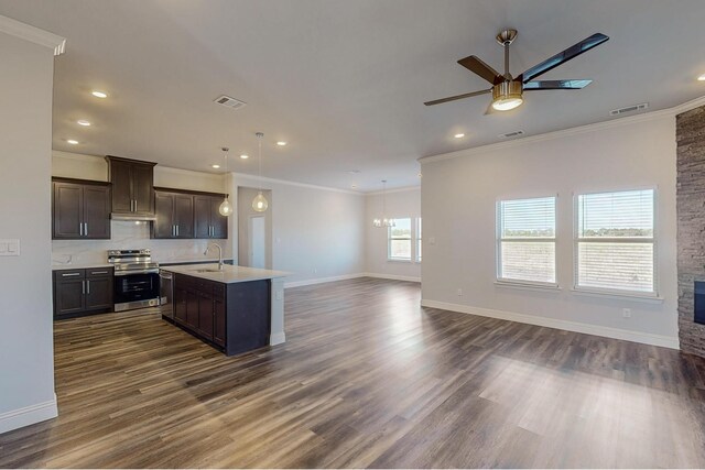 kitchen featuring dark hardwood / wood-style floors, stainless steel range with electric cooktop, a center island with sink, ornamental molding, and ceiling fan