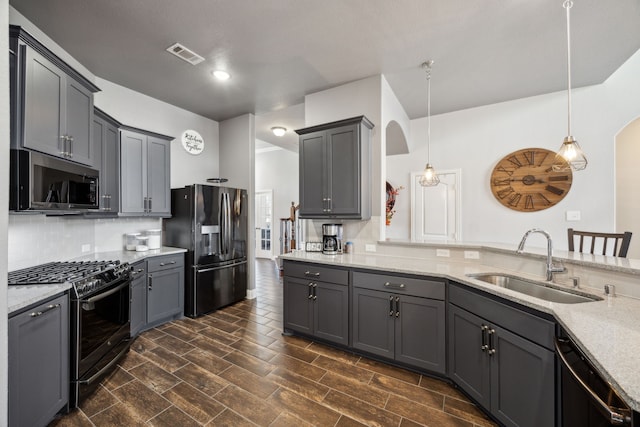 kitchen with decorative light fixtures, stainless steel appliances, dark wood-type flooring, and sink