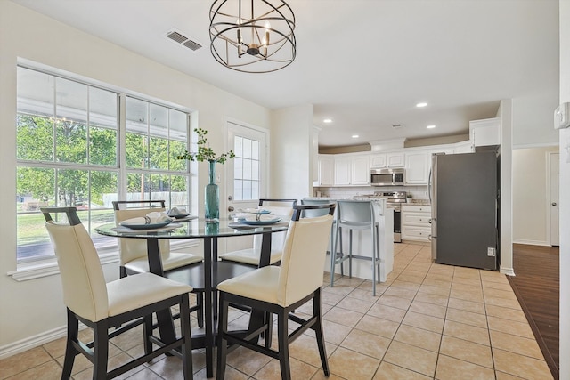 dining area with light hardwood / wood-style flooring and a chandelier