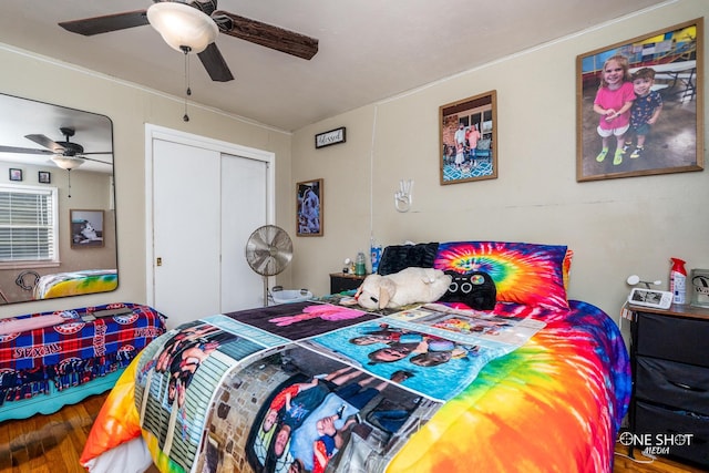 bedroom with wood-type flooring, ceiling fan, and a closet