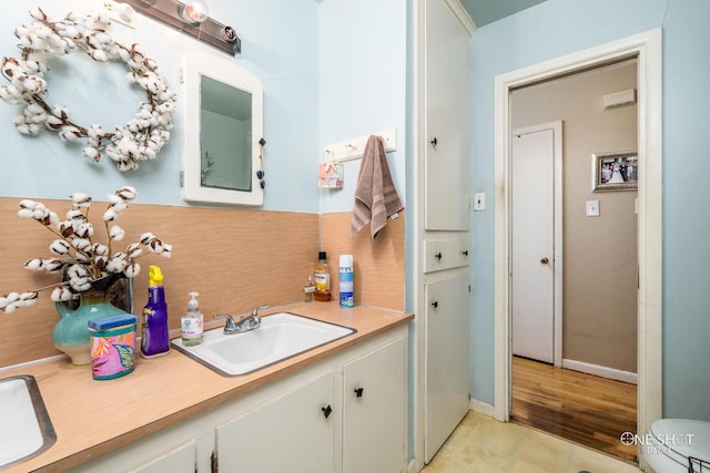 bathroom with vanity, toilet, and hardwood / wood-style flooring