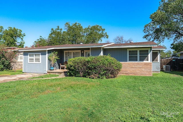 ranch-style house featuring cooling unit and a front yard