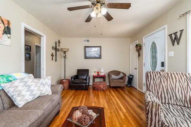 living room featuring hardwood / wood-style floors and ceiling fan