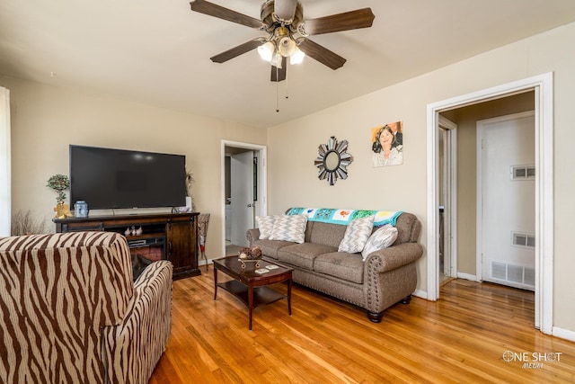 living room featuring ceiling fan and hardwood / wood-style flooring