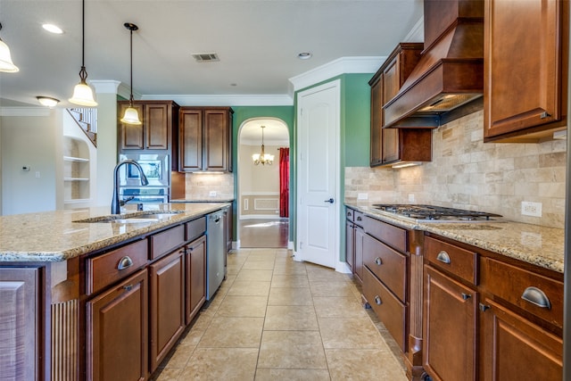 kitchen featuring pendant lighting, a kitchen island with sink, sink, custom exhaust hood, and appliances with stainless steel finishes