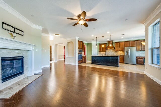 unfurnished living room with light hardwood / wood-style flooring, ceiling fan, and ornamental molding