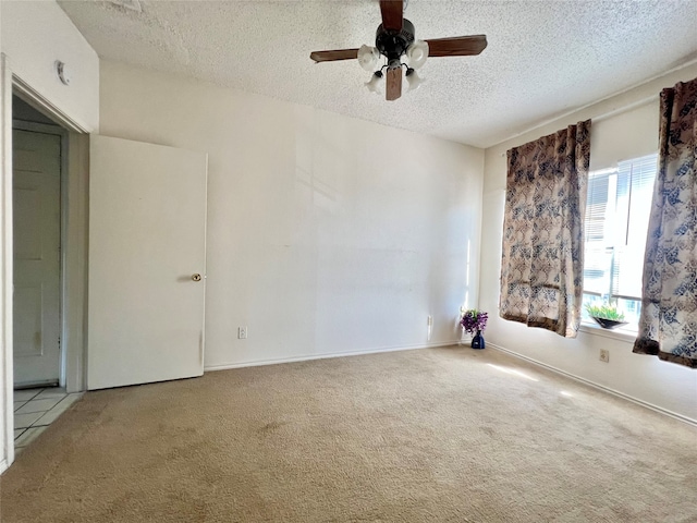 carpeted empty room with ceiling fan and a textured ceiling