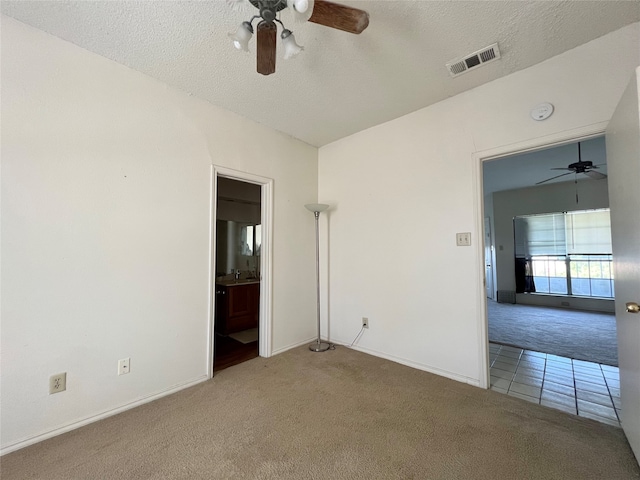 carpeted spare room with a textured ceiling and ceiling fan