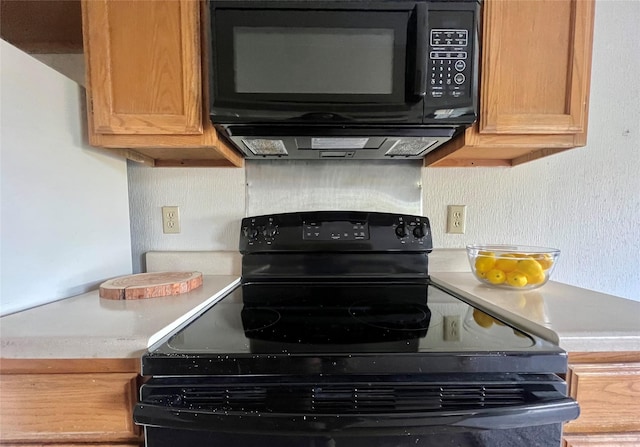 kitchen with brown cabinets, black appliances, and light countertops