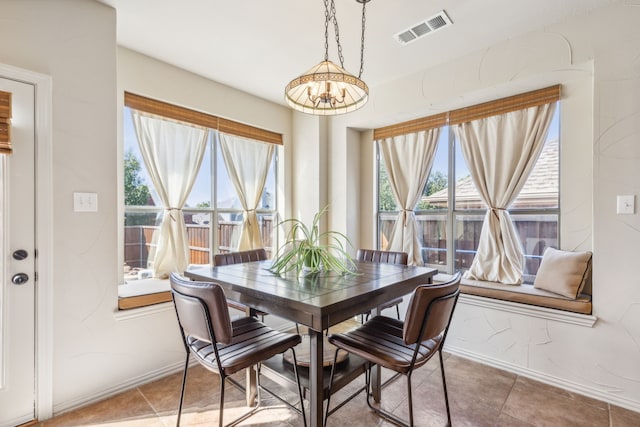 tiled dining space with an inviting chandelier