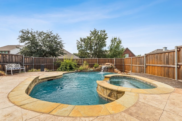 view of swimming pool with an in ground hot tub, pool water feature, and a patio