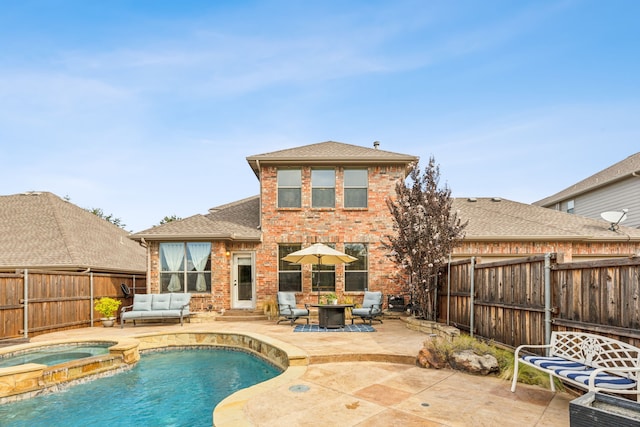 rear view of house featuring an outdoor living space, a patio, and a pool with hot tub