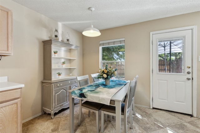 dining space featuring plenty of natural light and a textured ceiling