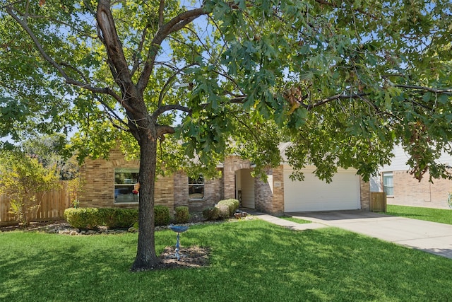 obstructed view of property featuring a garage and a front lawn