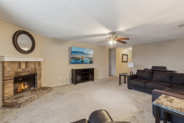 carpeted living room featuring ceiling fan, a textured ceiling, and a fireplace