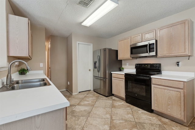 kitchen with stainless steel appliances, sink, a textured ceiling, and light brown cabinetry