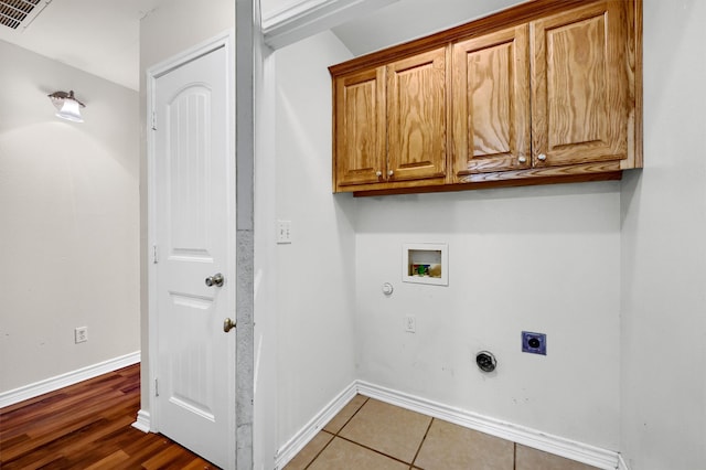 laundry room featuring hookup for an electric dryer, hookup for a gas dryer, cabinets, hardwood / wood-style flooring, and hookup for a washing machine