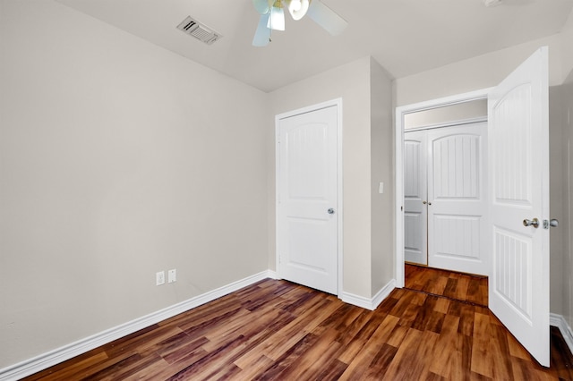 unfurnished bedroom featuring ceiling fan, a closet, and dark hardwood / wood-style floors