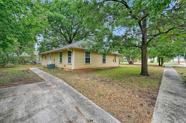 view of side of property with a lawn and central AC unit