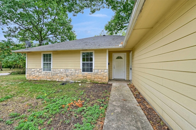 entrance to property featuring a lawn