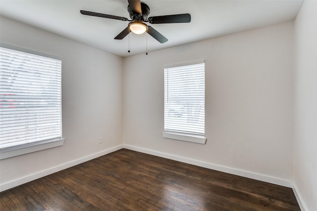 spare room featuring a ceiling fan, baseboards, and dark wood-style flooring