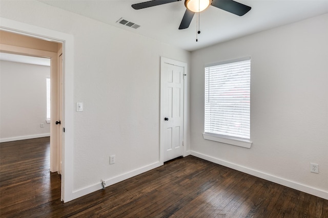 unfurnished bedroom featuring a closet, visible vents, dark wood-type flooring, a ceiling fan, and baseboards