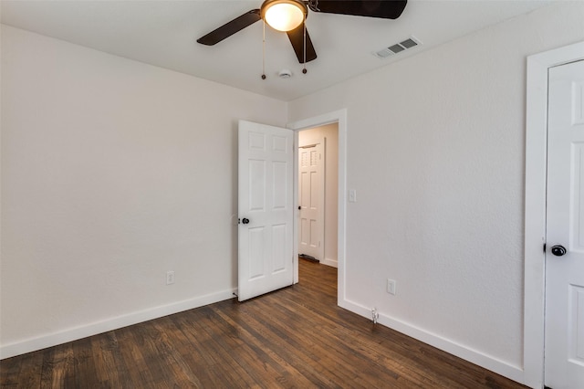 unfurnished bedroom featuring dark wood-type flooring, visible vents, baseboards, and a ceiling fan