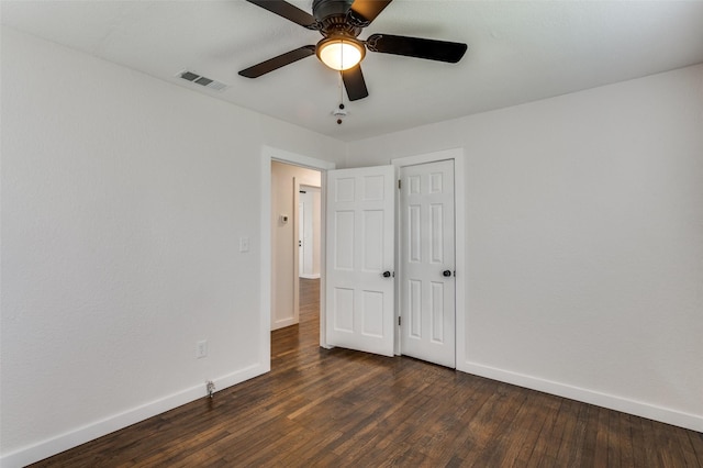 unfurnished bedroom with baseboards, visible vents, ceiling fan, and dark wood-type flooring