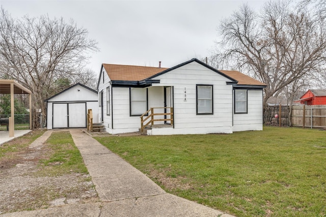 bungalow-style home with a shingled roof, fence, an outdoor structure, a shed, and a front yard