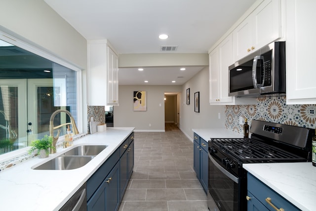 kitchen with blue cabinets, white cabinets, stainless steel appliances, and sink