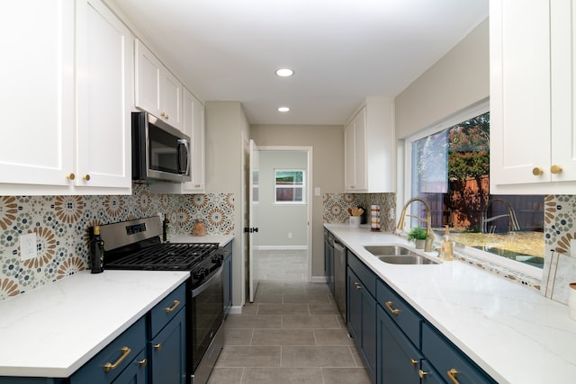 kitchen with white cabinetry, sink, blue cabinetry, and stainless steel appliances