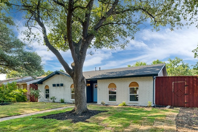 single story home featuring a storage shed and a front yard