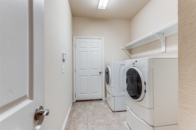 washroom with light tile patterned flooring and washing machine and clothes dryer