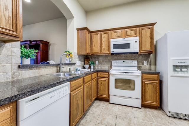 kitchen with white appliances, light tile patterned flooring, tasteful backsplash, and sink