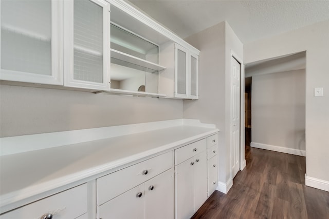 kitchen featuring a textured ceiling, dark hardwood / wood-style flooring, and white cabinetry