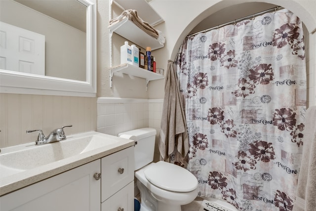 bathroom with walk in shower, vanity, and toilet