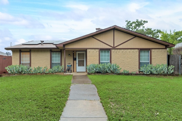 ranch-style house with a front lawn and solar panels