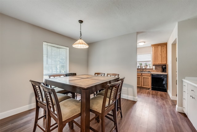 dining space featuring a textured ceiling, dark hardwood / wood-style floors, and sink