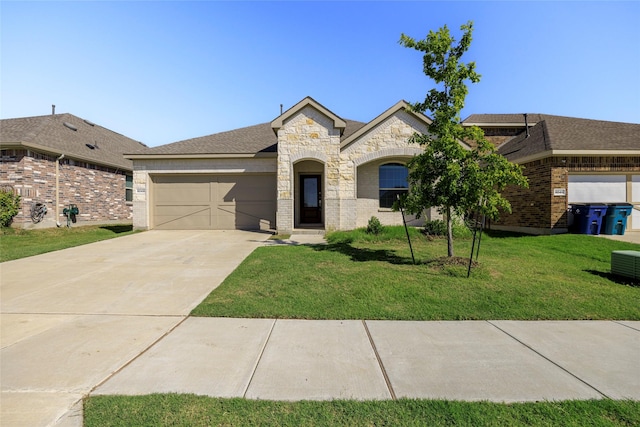 6049 Pensby Dr, Celina, TX 76227 - french provincial home featuring stone siding, an attached garage, a front yard, brick siding, and driveway