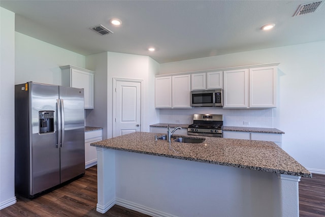 6049 Pensby Dr, Celina, TX 76227 - kitchen featuring visible vents, appliances with stainless steel finishes, dark stone countertops, white cabinetry, and a sink