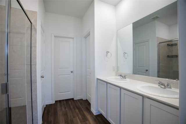 bathroom with vanity, hardwood / wood-style floors, and a shower with door