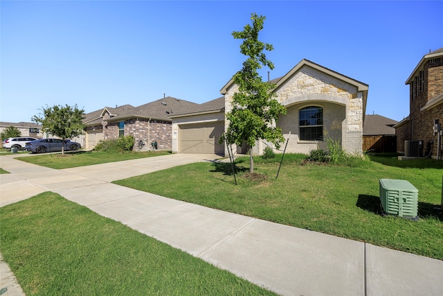 view of front of property with central AC unit, a garage, and a front lawn