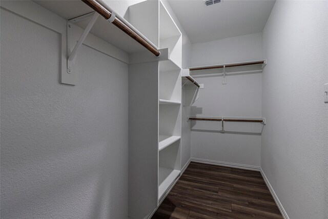 spacious closet with dark hardwood / wood-style floors