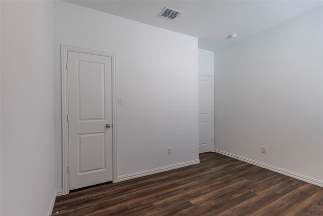 unfurnished room with dark wood-type flooring