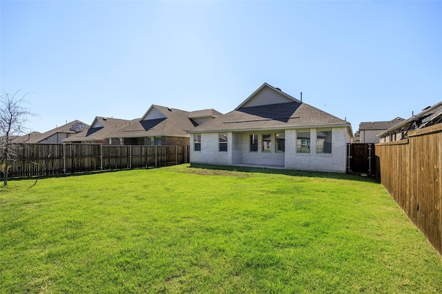 6049 Pensby Dr, Celina, TX 76227 - back of house featuring a fenced backyard, brick siding, roof with shingles, and a lawn