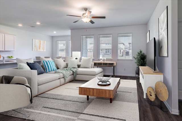 living room featuring ceiling fan, sink, and dark wood-type flooring