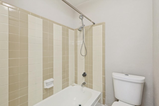 bathroom featuring tiled shower / bath and toilet