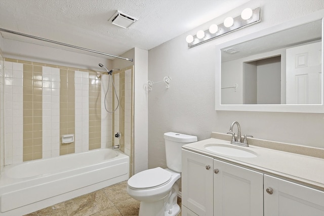 full bathroom featuring a textured ceiling, vanity, toilet, and tiled shower / bath