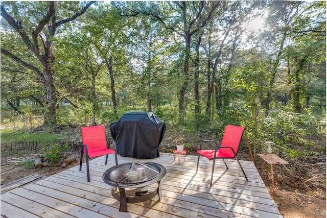 wooden deck with grilling area and an outdoor fire pit